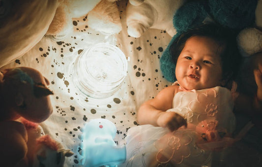 Adorable baby lying among toys in warm indoor lighting, creating a magical and playful atmosphere.
